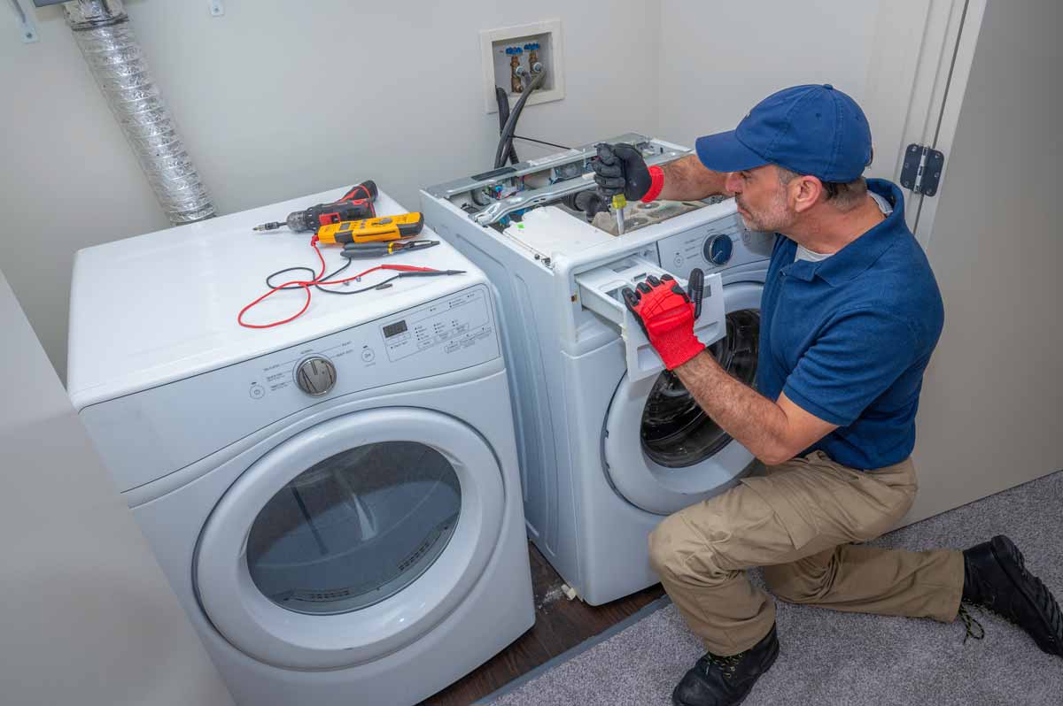Technician repairing detergent drawer on a washing machine